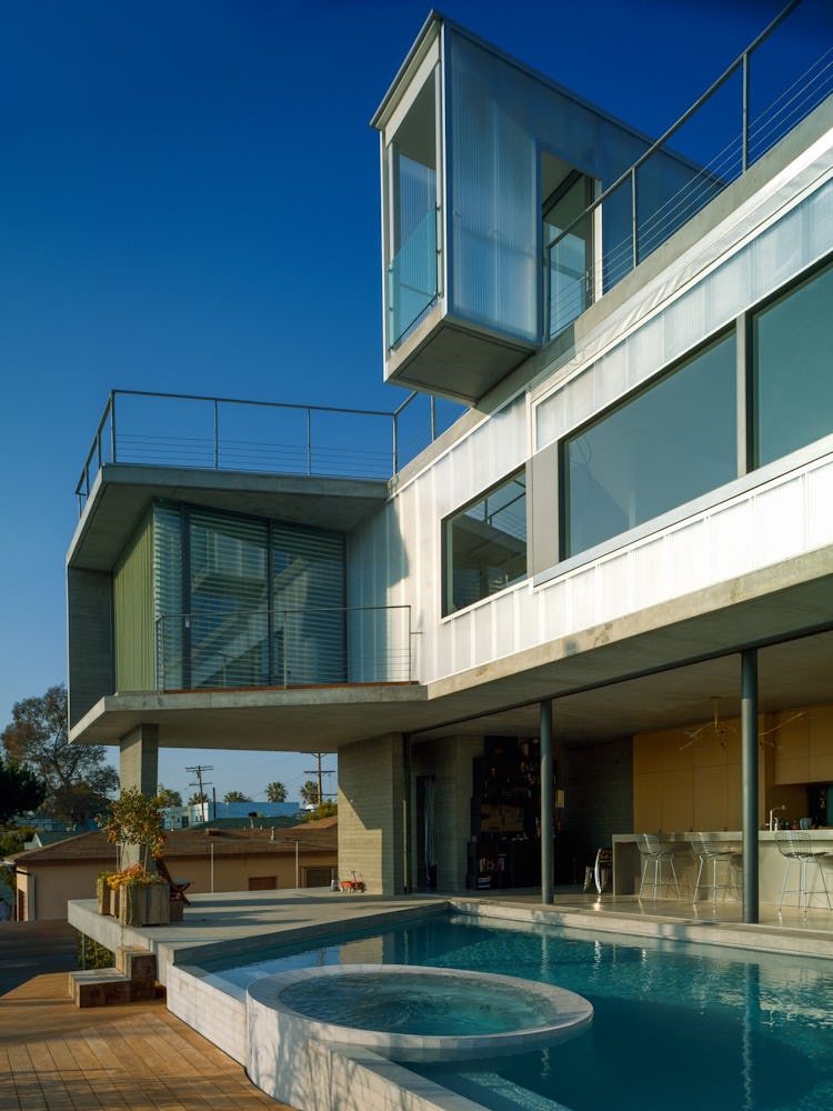 A house with large windows designed by  Kulapat Yantrasast with the pool facing the street 