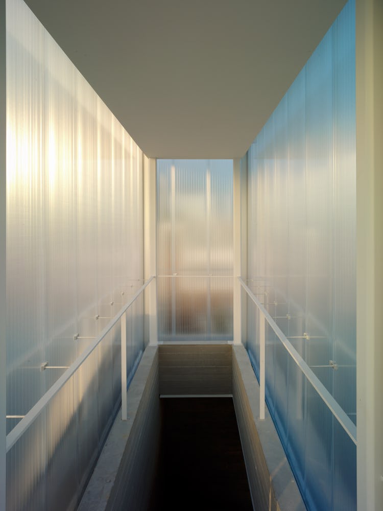 A stairwell that leads to a roof, housed in a polycarbonate box.