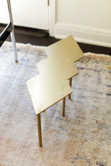 A tiny golden table placed on a white carpet
