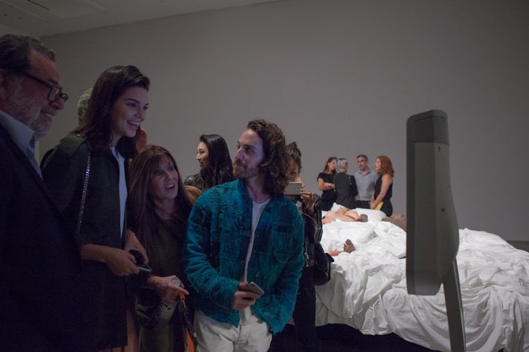 Kendall Jenner talking to visitors while looking at the Famous sculpture by Kanye West