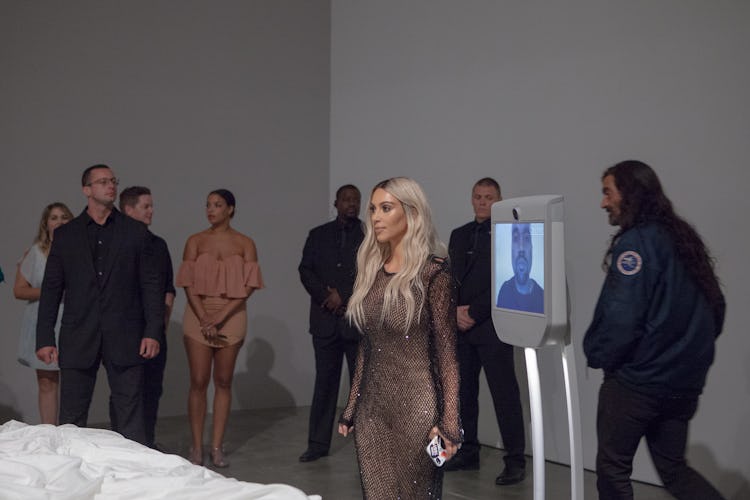 Kim Kardashian and a group of people standing behind her 