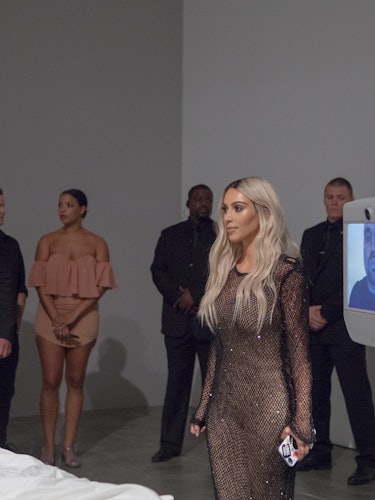 Kim Kardashian and a group of people standing behind her 