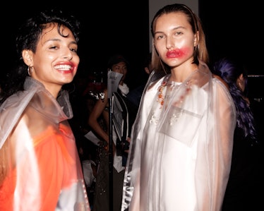 Two models with red lipstick smudged across their lips and cheeks backstage at the VFiles Spring 201...