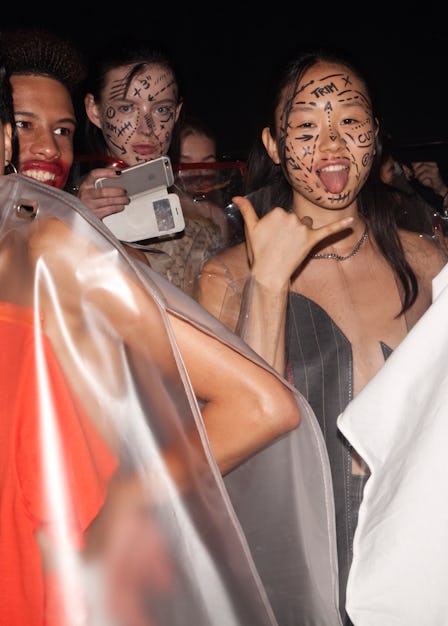 Backstage at VFiles Spring 2017, models wearing vinyl ponchos and face paint