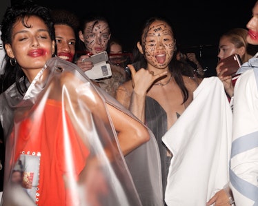 Backstage at VFiles Spring 2017, models wearing vinyl ponchos and face paint