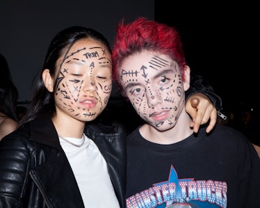 Two models backstage at VFiles Spring 2017 show with their faces covered in tattoos 