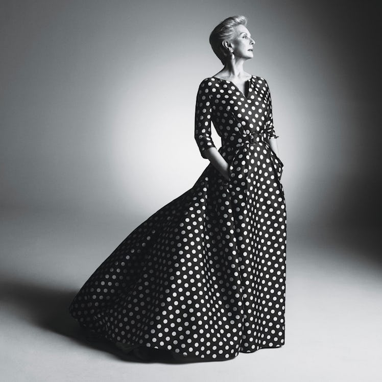Carolina Herrera posing in a black gown with white dots