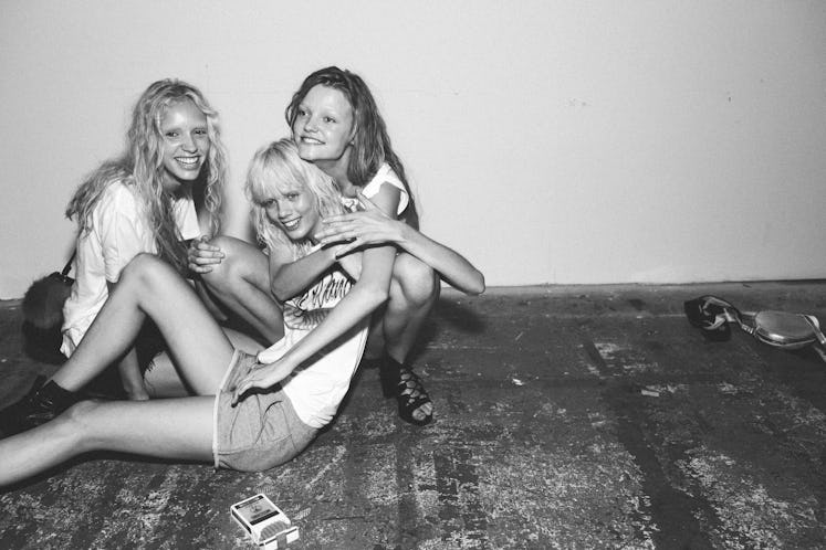 Three models sitting on the floor backstage at Alexander Wang Spring 2017