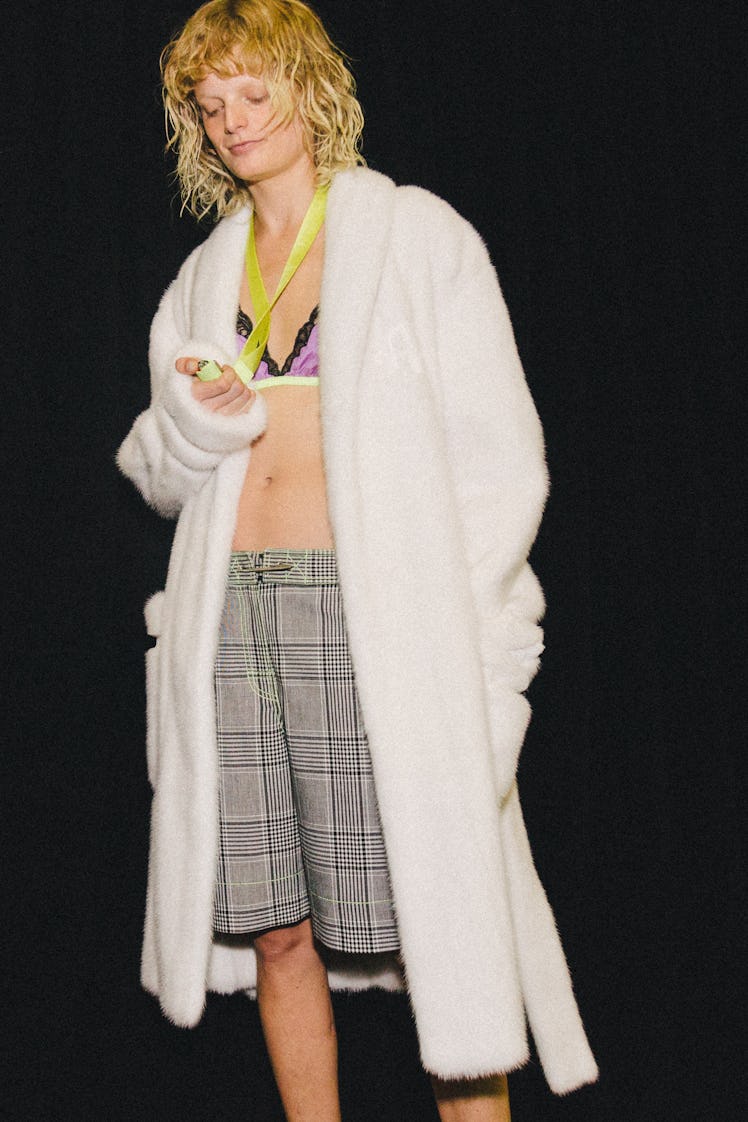 A model in a white Alexander Wang Spring 2017 teddy coat, plaid shorts and a pink bra.