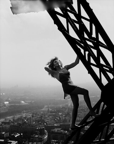 Tina Turner posing for a photo on the construction of the Paris Eiffel Tower