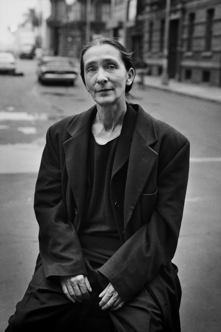Pina Bausch posing in a black shirt and coat combination