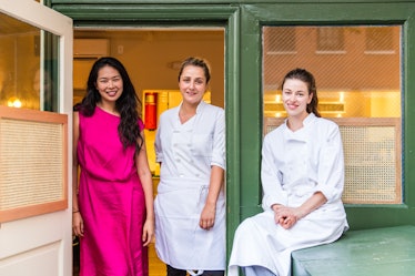 Annie Shi, Jess Shadbolt, and Clare de Boer posing for a photo at the entrance of the King restauran...
