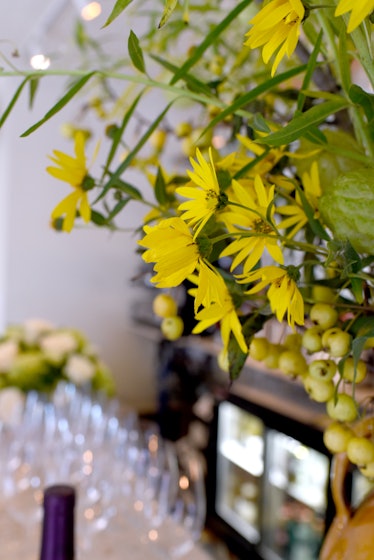 Yellow flowers next to glasses at a desk at the King restaurant