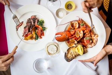 Two plates with lobsters and steak served on a table at the King restaurant