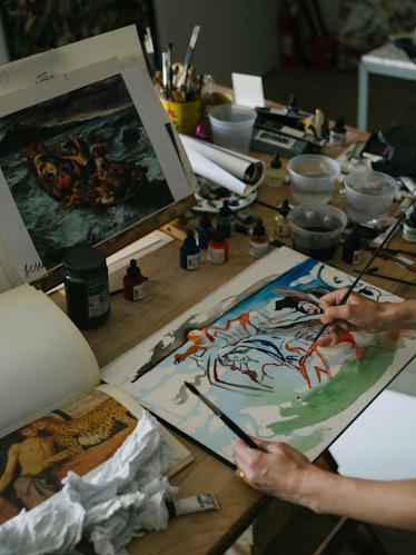 Cecily Brown holding one of her paintings and working on it in her New York studio