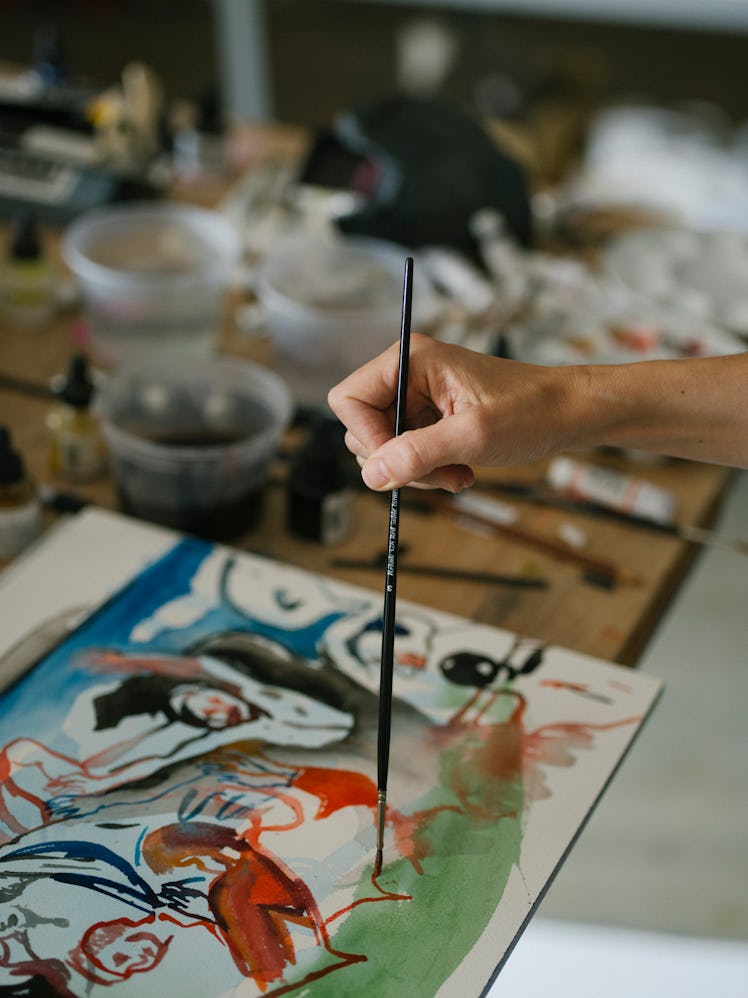 Cecily Brown using a brush to work on her painting in her New York studio