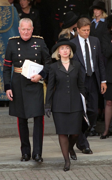 Hillary Clinton in a black blazer, skirt, and hat in February 1997