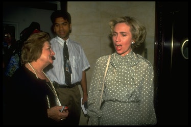 Hillary Clinton in a grey-white polka dot blouse and skirt speaking to a woman in May 1993