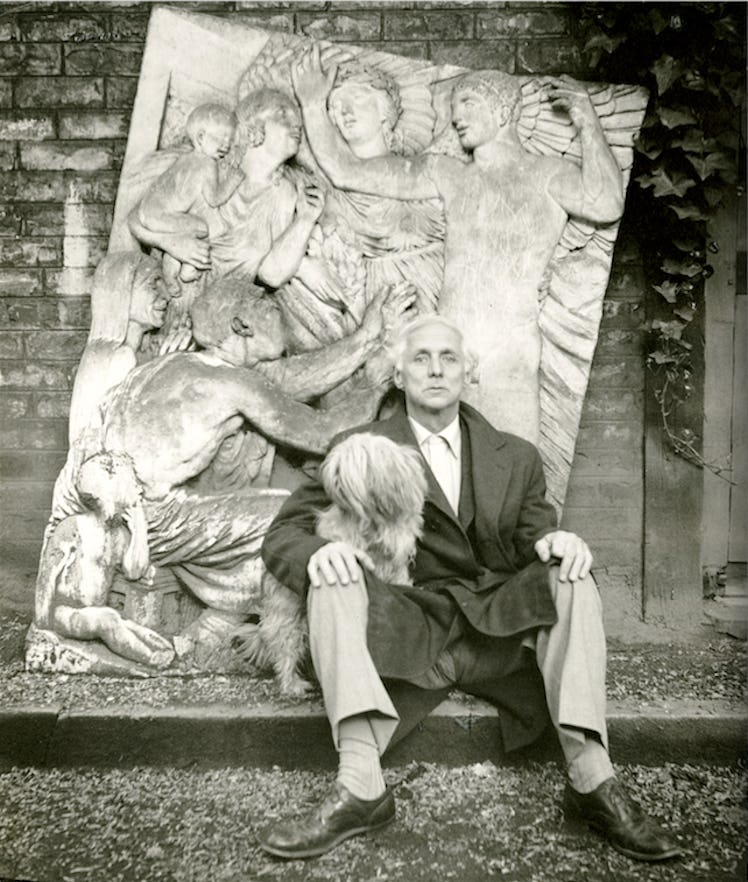 Max Ernst sitting while wearing a coat