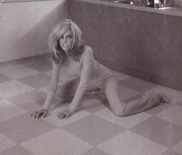 Miles Aldridge's polaroid featuring  a woman crawling on a checkered floor