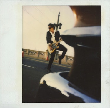 Happy Massee’s polaroid of a man playing a guitar on the street