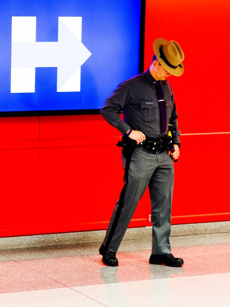 A New York police officer standing and looking at the floor at the Jacob K. Javits Convention Center...