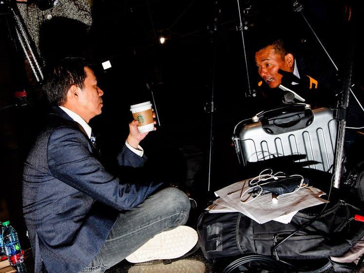 Two men sitting on the floor and drinking coffee during Hillary Clinton's election night party 
