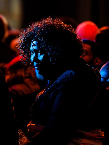 A closeup of a woman looking into the distance in the crowd during Hillary Clinton's election night ...