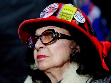 A brunette woman with glasses and a red hat with Hillary Clinton badges at her election night rally 