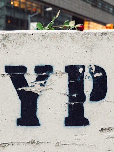 A white wall with sprayed black letters 'NYPD'