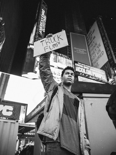 A man standing and holding a poster with the text 'TRUCK FUMP'