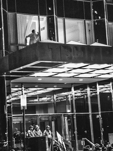 A crowd with protesters assembling in front of a building during night time