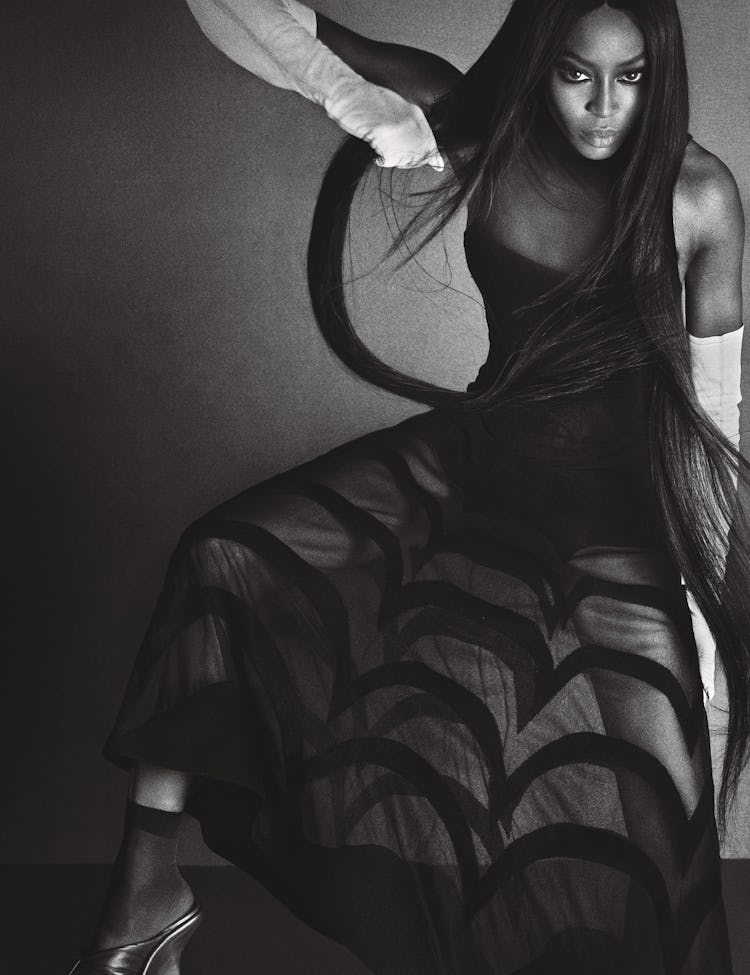 Naomi Campbell posing in a black tulle dress
