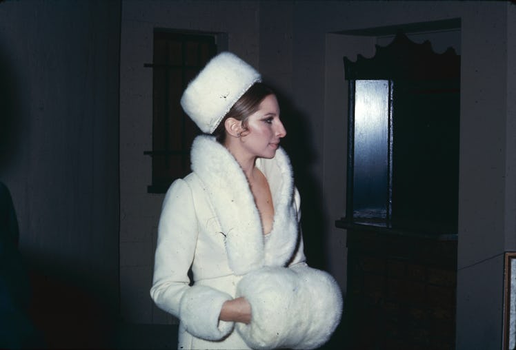 Barbra Streisand in a matching white fur coat, hat and hand warmer in 1969