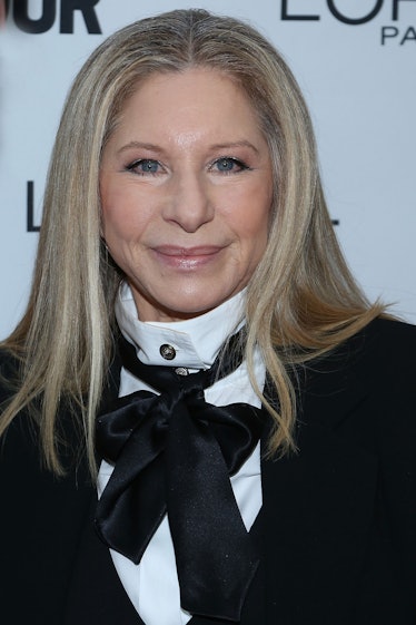 Barbra Streisand in a white shirt, black blazer and black satin scarf at a red carpet event