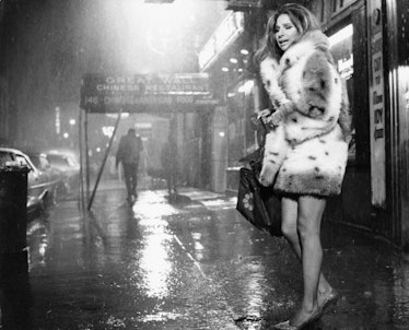 Streisand wearing a fur jacket and fishnets in the rain