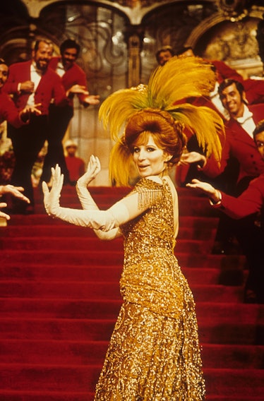 Barbra dancing in a gold sequin gown with huge feathers in her bun 