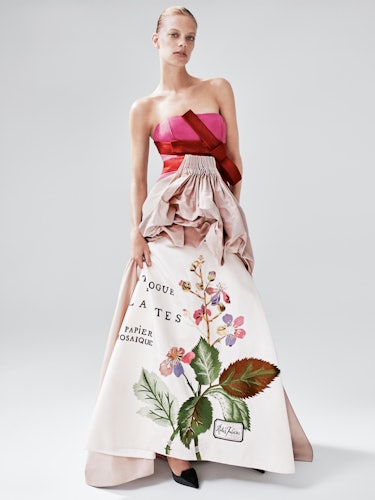A model wearing a dress with a pink corset and a long floral print skirt segment by Carolina Herrera