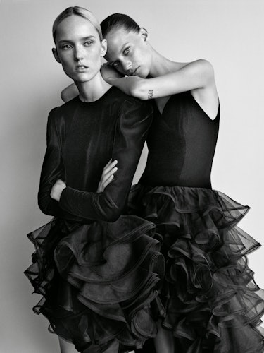 Two models posing in black tulle dresses by Carolina Herrera