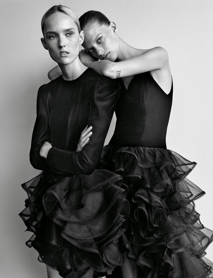 Two models posing in black tulle dresses by Carolina Herrera