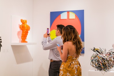Guest taking photos of a sculpture displayed at the Art Basel Miami Beach 2016