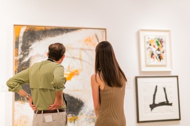 Attendees exploring paintings at the 2016 Art Basel Miami Beach.
