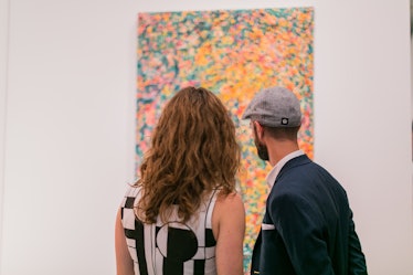 Art enthusiasts observing artworks at Art Basel Miami Beach 2016.