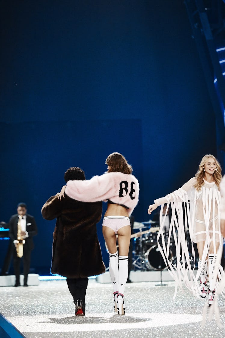 Bruno Mars and a model with her hand around Bruno's neck walking at the 2016 Victoria’s Secret Fashi...