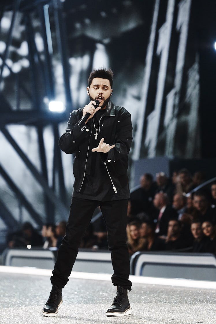 The Weeknd in a black jacket, shirt, trousers and black-white sneakers performing at the 2016 Victor...