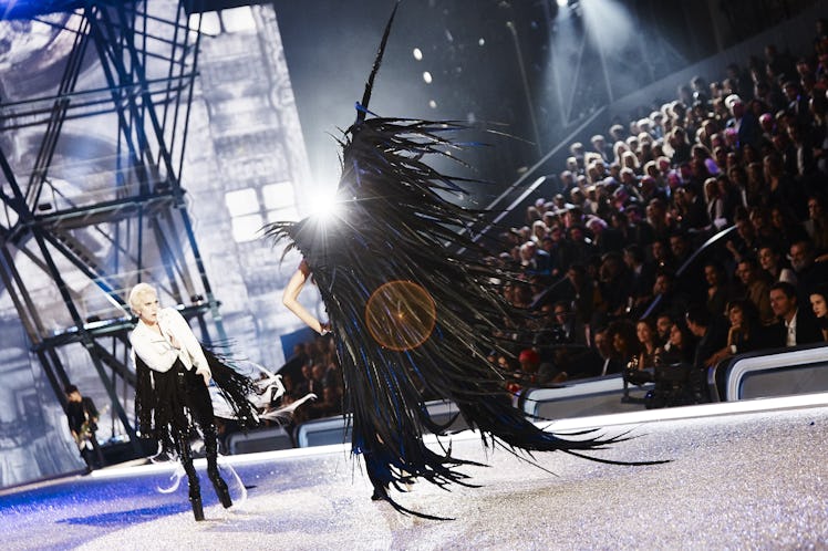 Lady Gaga performing while Joan Smalls is walking with large black wings at the 2016 Victoria’s Secr...