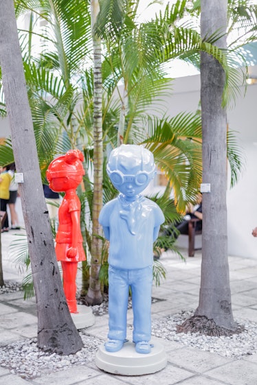 Blue and orange sculptures of boy and girl outside at Art Basel Miami Beach 2016.
