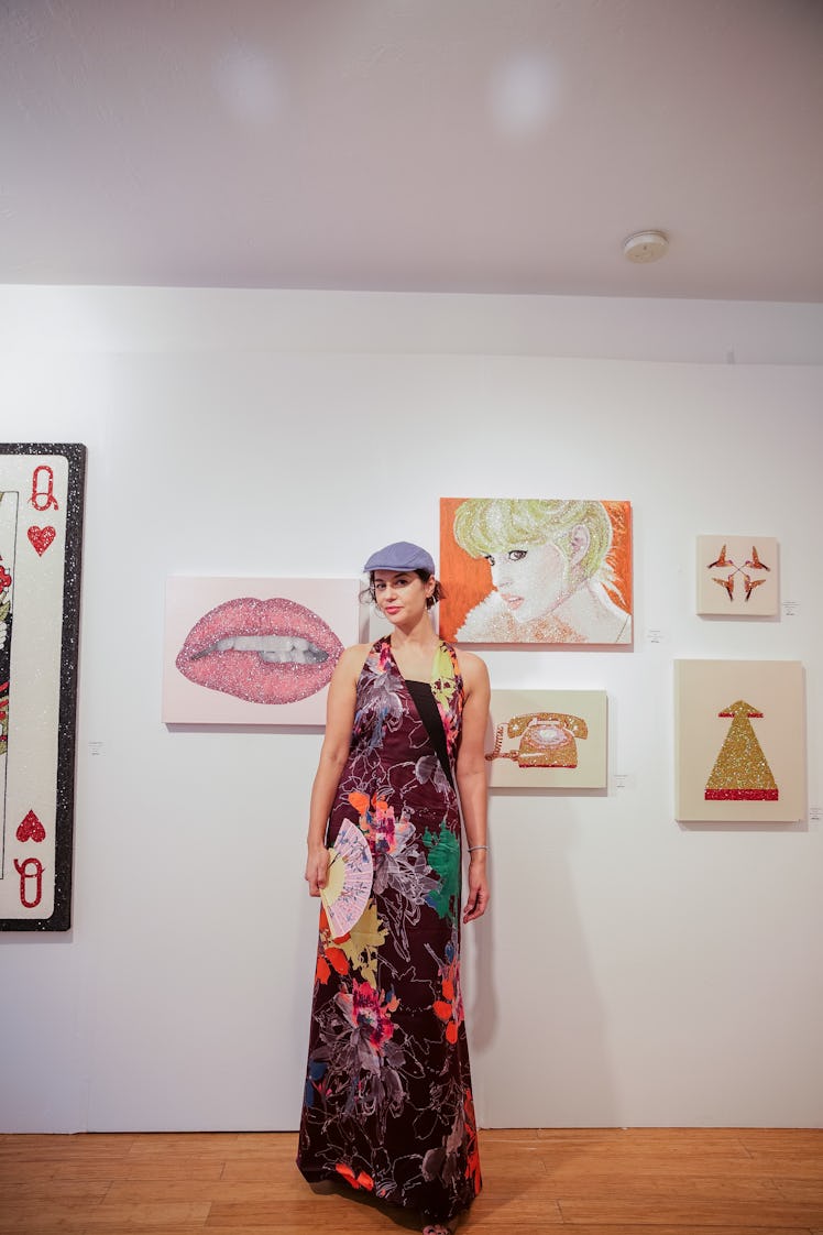 A woman in a floral maxi dress posing in front of an artwork at Art Basel Miami Beach 2016.