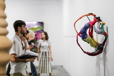 Attendees exploring paintings at the 2016 Art Basel Miami Beach.