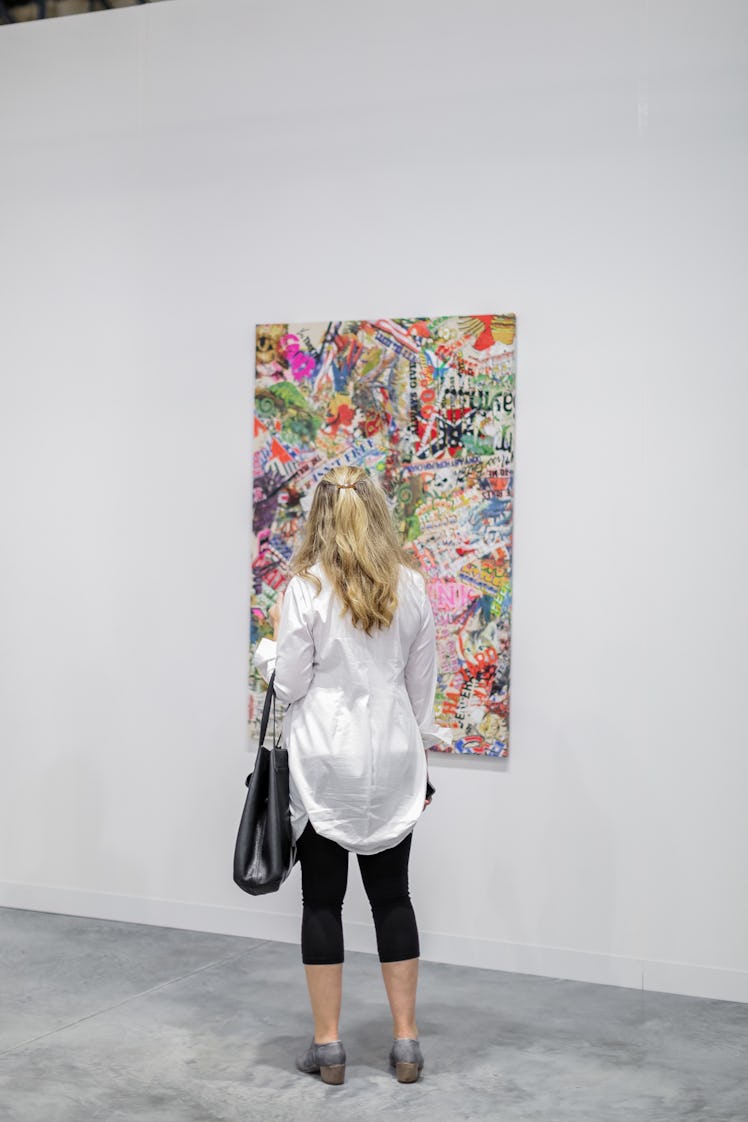 A visitor examining a painting at the 20 16 Art Basel Miami Beach exhibition.